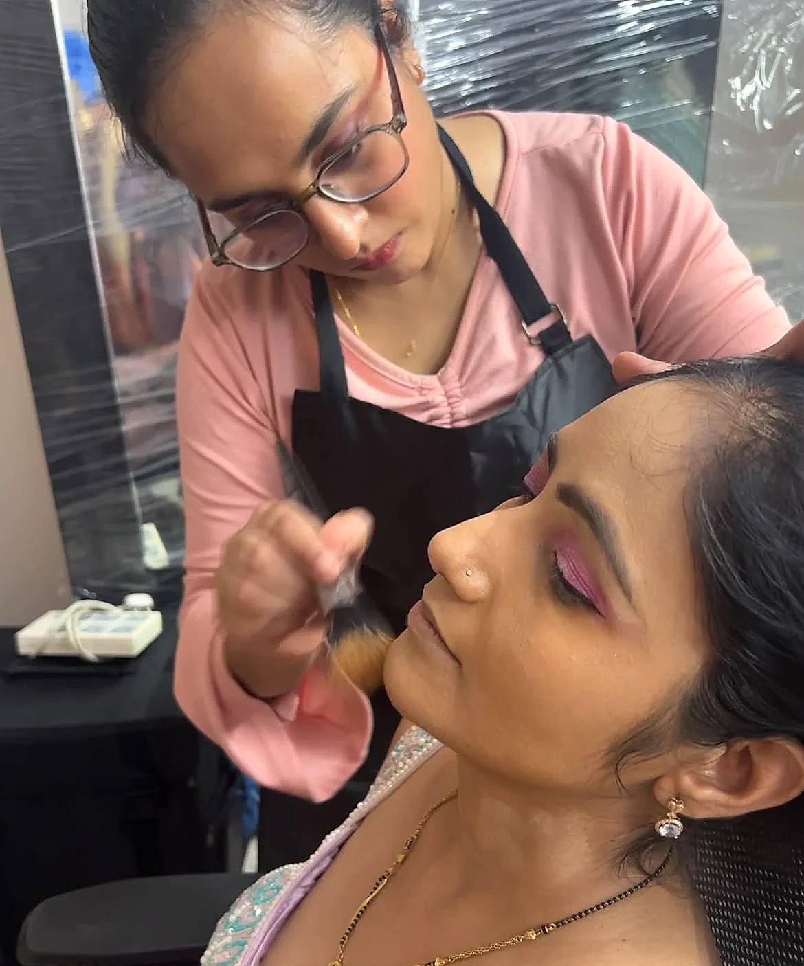 Twinkle Arora blending client facial contour and makeup makeover at Glamour Guru