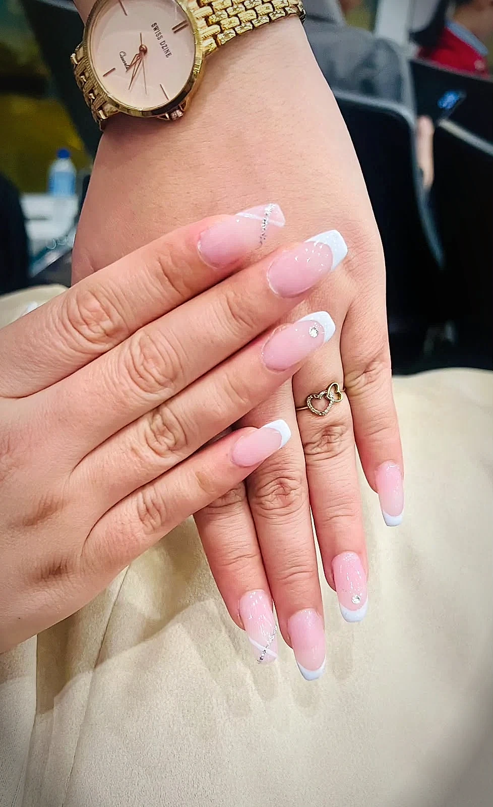 Top view of sleek French ombre nail extensions with crystal studs